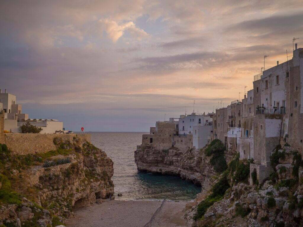 sunrise at lama monachile the famous beach of polignano a mare with a view of the city on the rock